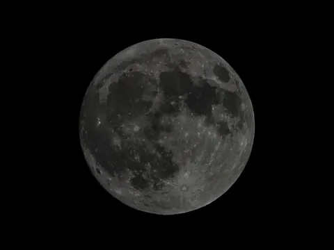 A detailed full moon against a black sky.