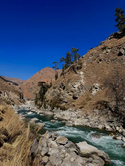 A clear mountain river flowing through a rocky gorge.