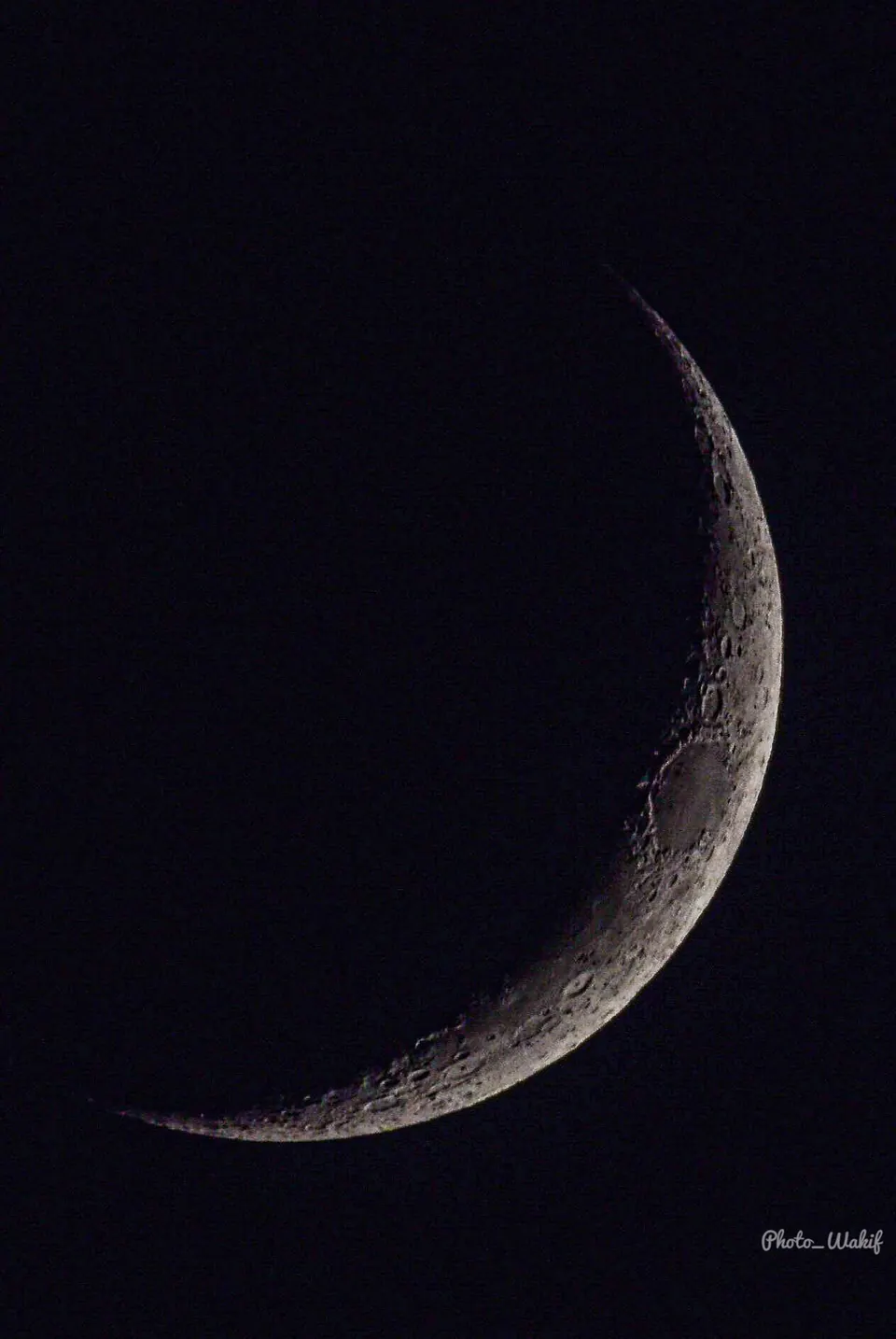 A fine crescent moon in a black sky.