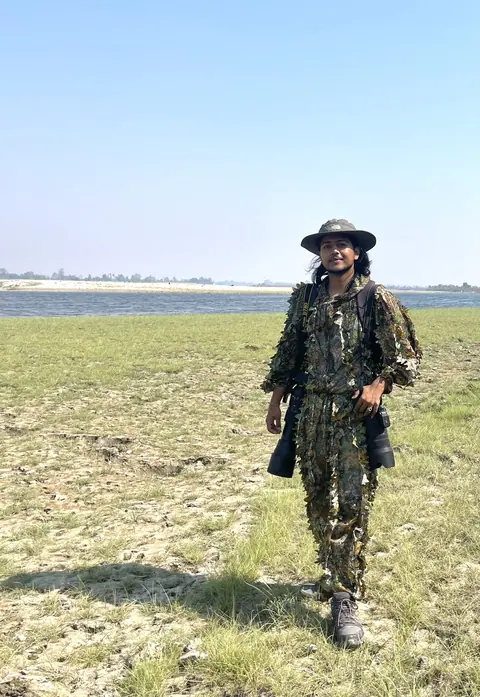 A field guide crossing an open wetland.