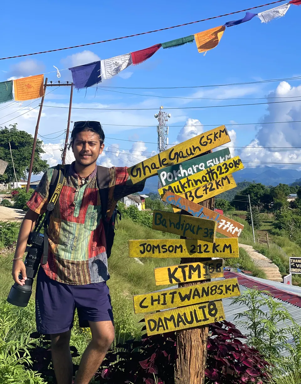 Wakif Wagle beside a high-altitude trail sign.