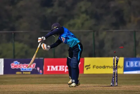 A batter playing a shot during a cricket match.