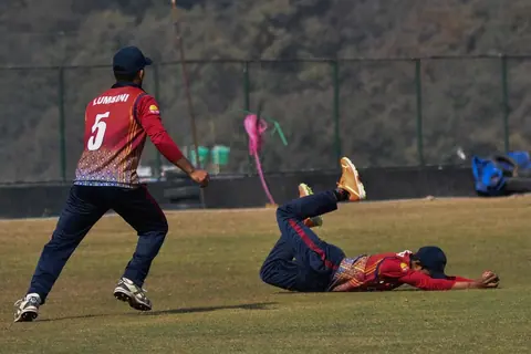 A diving fielding effort on the cricket outfield.