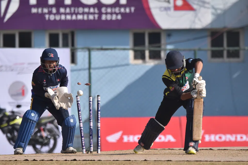 A women's cricket match photographed from beside the wicket.