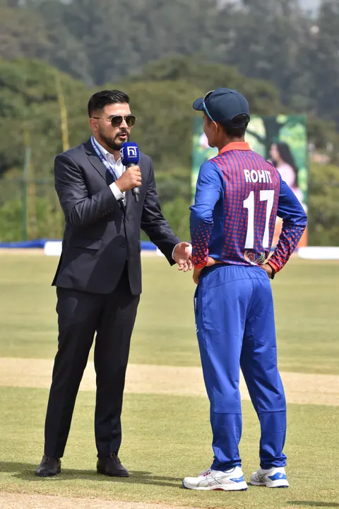 Two cricket captains meeting on the field.