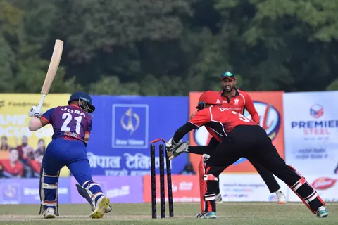 A wicketkeeper and batter at the moment of play.