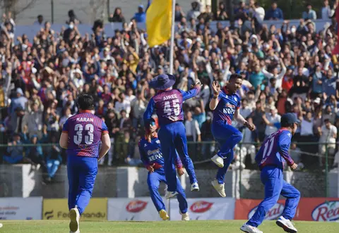 Nepal cricket players celebrating before a packed stand.